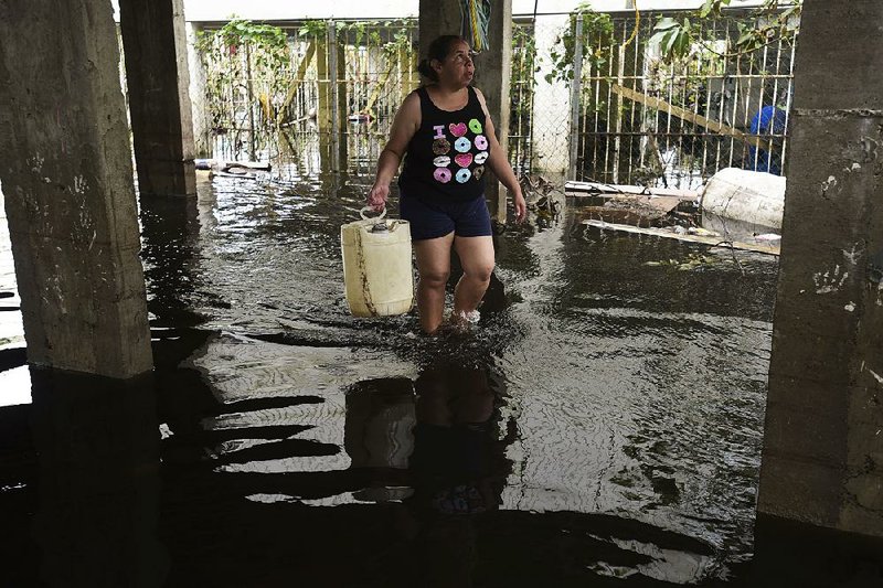 A resident wades through a flooded area in the aftermath of Hurricane Maria on Wednesday in Catano, Puerto Rico. A week since the passing of Maria many are still waiting for help from anyone, whether from the federal or Puerto Rican government. 