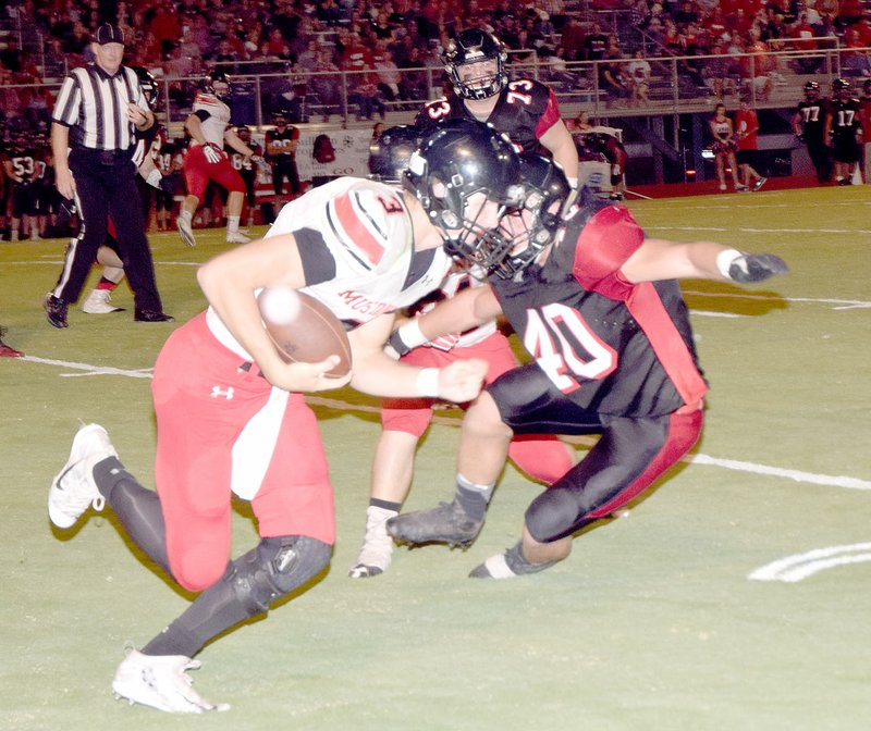 Photo by Rick Peck
McDonald County quarterback Peyton Barton tires to get around Lamar's Travis Bailey during the Mustangs' 50-8 loss on Sept. 22 at Lamar High School.