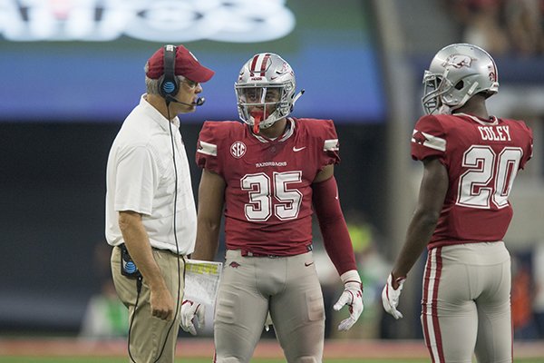 Arkansas defensive coordinator Paul Rhoads, left, talks with linebacker Dwayne Eugene (35) and safety De'Andre Coley (20) during a game against Texas A&M on Saturday, Sept. 23, 2017, in Arlington, Texas. 