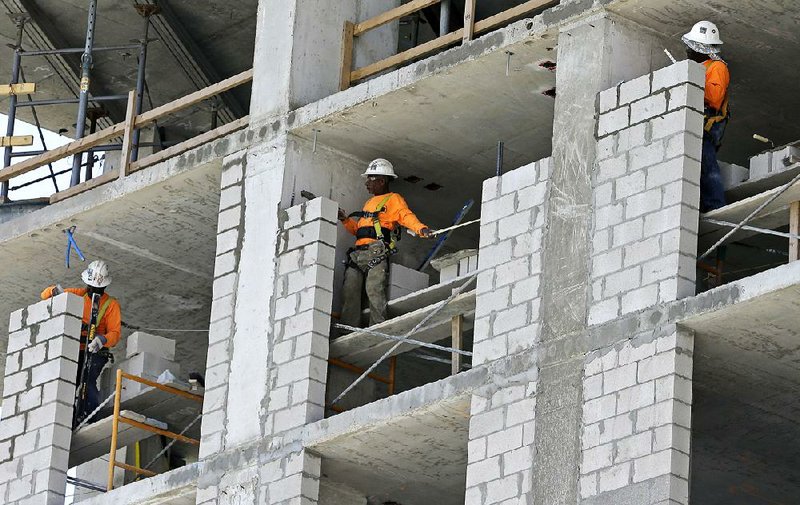 Bricklayers work on an apartment high-rise in Miami in May. The Commerce Department said Thursday that the U.S. economy grew at an annual rate of 3.1 percent in the spring. 