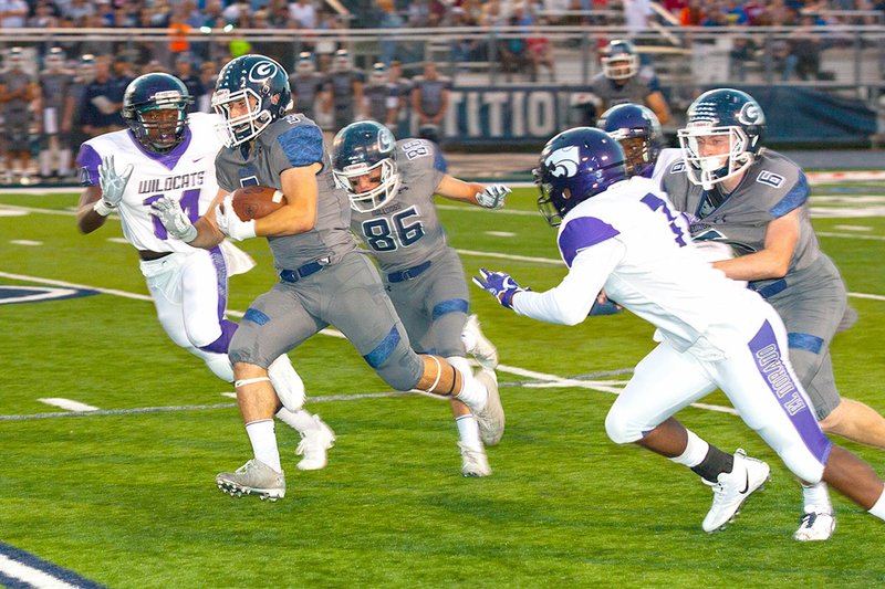 Special to NWA Democrat-Gazette/MARK STALLINGS Greenwood&#8217;s Peyton Holt (3) breaks away from several El Dorado defenders with the help of key blocks from teammates Friday in Greenwood.