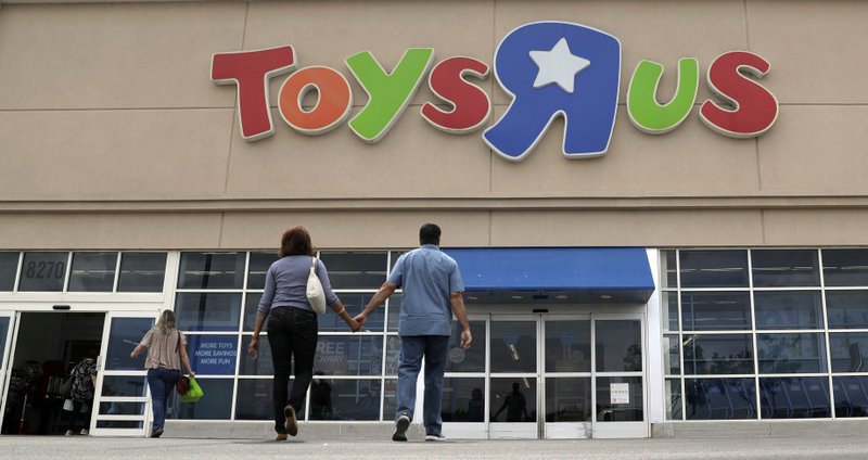 In this Tuesday, Sept. 19, 2017, photo, shoppers walk into a Toys R Us store, in San Antonio. Toys R Us, trying to reorganize under bankruptcy leading into the holiday season, was seeing overall sales fall and those at established locations drop even more sharply as it was heading for a Chapter 11 filing. (AP Photo/Eric Gay)