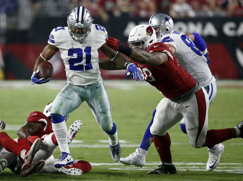 FILE - In this Sept. 25, 2017, file photo, Dallas Cowboys running back Ezekiel Elliott (21) carries as Arizona Cardinals defensive tackle Robert Nkemdiche (90) misses the tackle during the second half of an NFL football game in Glendale, Ariz.  (AP Photo/Ross D. Franklin, File)