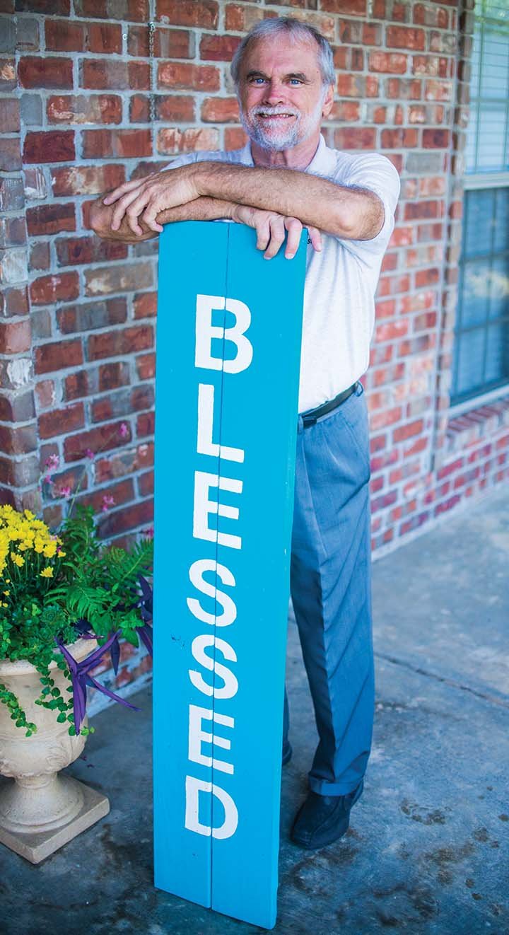 The Rev. LaVon Post stands with a sign on his front porch at his home in Conway, where he moved in late June after retiring from First United Methodist Church in Malvern. He started in July as part-time pastor for St. Paul United Methodist Church in Little Rock, which has a black congregation.