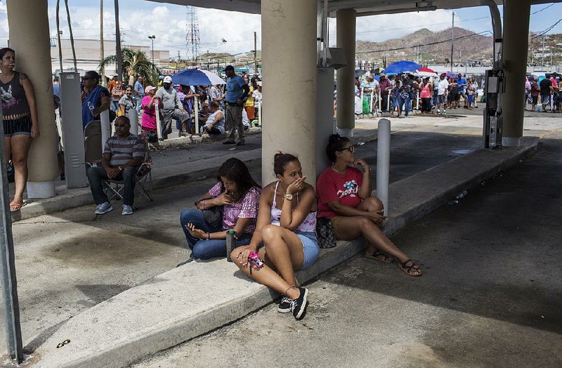 People wait Friday outside a bank in Humacao, Puerto Rico. Desperate Puerto Ricans are still struggling to obtain basic supplies. 