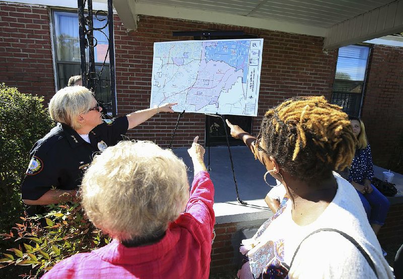 Little Rock Assistant Police Chief Alice Fulk, (from left) City Director Joan Adcock and Pamela Bingham, president of the Upper Baseline Windamere Neighborhood Association, on Friday, Sept. 29, 2017, examine a map of areas where a grant will allow AmeriCorps members to do some repairs on homes.