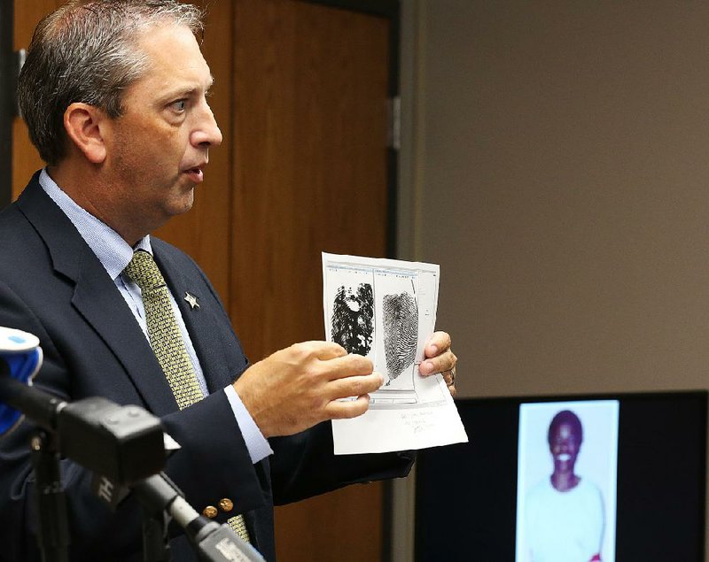 Sgt. Mike Blain of the Pulaski County sheriff’s office shows a fingerprint comparison in a homicide case from February 2014. 