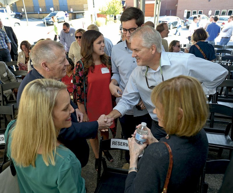 NWA Democrat-Gazette/ANDY SHUPE Jerry Brewer (left) shakes hands Friday with Ken Young as Brewer's wife, Kay (clockwise from right) speaks with Regina Young, while Jamie Young and her husband Corben, look on during a reception and tour of the new Brewer Family Entrepreneurship Hub on Mountain Street in Fayetteville. The center provides working and meeting space to serve as a training center for new entrepreneurs in Northwest Arkansas.