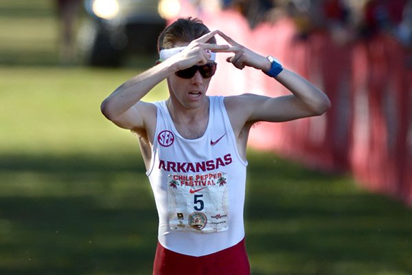 Arkansas senior Alex George "throws the A" Saturday, Sept. 30, 2017, as he comes in to win the men's collegiate 10k during the 29th annual Chile Pepper Cross Country Festival at Ari Park in Fayetteville. 