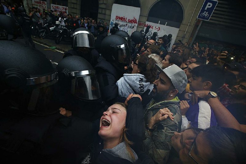 A girl grimaces Sunday as members of the Spanish National Police push people away from a Barcelona school that had been designated as a polling station in the Catalonia region’s independence referendum.  