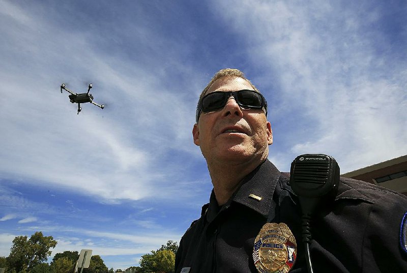 As a drone flies overhead, North Little Rock Police Lt. Jim Scott talks Friday about the possible law enforcement uses for the technology. 