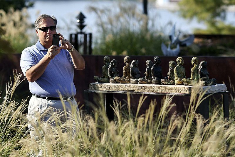 John Mayner takes a photo of the sculpture Renewal Ritual on Sunday before the start of a news conference announcing the addition of more artwork at the Vogel Schwartz Sculpture Garden in Little Rock. 