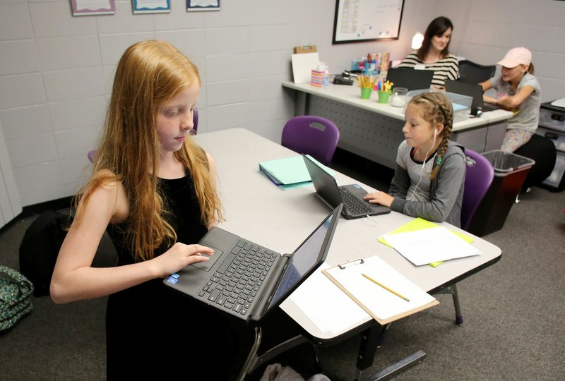 NWA Democrat-Gazette/DAVID GOTTSCHALK Kali Daniels (left), a fourth-grader at Fayetteville Virtual Academy, arrives Tuesday in Melissa Green’s fourth- and fifth-grade class at the school in Fayetteville. The school continues to expand in its second year and has added grades nine through 12 and added six educators this year.