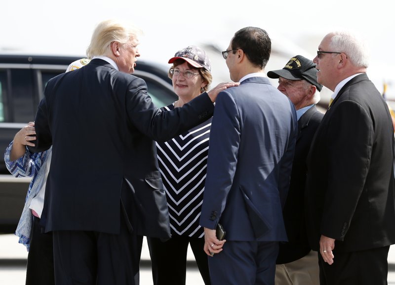 President Donald Trump puts his hand on the shoulder of Treasury Secretary Steve Mnuchin as he is greeted by people as he steps off Air Force One, Wednesday, Sept. 27, 2017, in Indianapolis. (AP Photo/Alex Brandon)