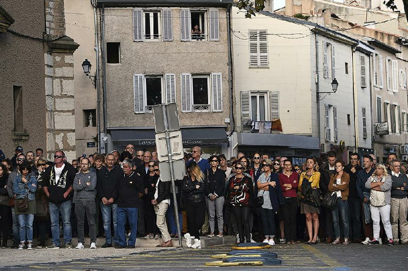 Residents of Eguilles, France, gather for a moment of silence Monday in remembrance of the two women who were fatally stabbed outside a train station in Marseille.