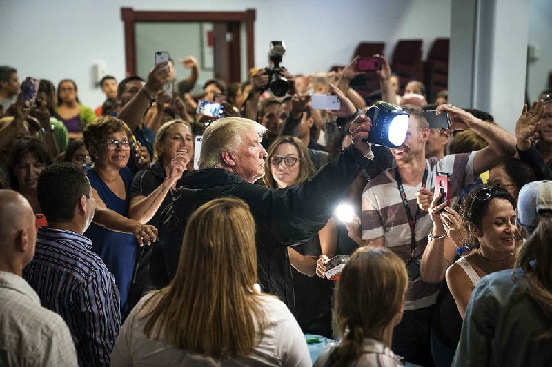 President Donald Trump hands out flashlights and other supplies Tuesday at a church in Guaynabo, a town just south of Puerto Rico’s capital, San Juan. 