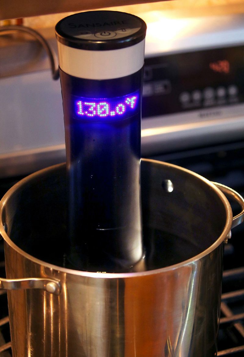 The immersion circulator attaches to the side of a pot to heat and circulate the water for even cooking. 