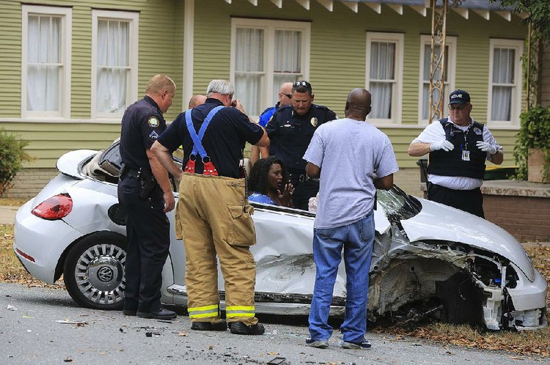 City Director Doris Wright talks with Little Rock police officers and firefighters Tuesday. She lost control of her vehicle when a suspect in a disturbance jumped in her car, authorities said. 
