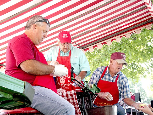 FILE PHOTO Volunteers stayed busy during the 2016 Arkansas Apple Festival, slicing apples and handing out free samples. Some of the volunteers included Josh Moore, Doug Hulse and Jerry McDonald.