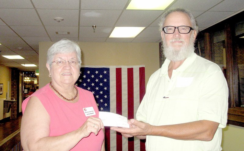 Photo submitted Lorna Sterrett, secretary of the Regional National Cemetery Improvement Corp. in Fayetteville,, and Jonathan Boswell, treasurer of the Bella Vista Chapter of the Military Officers Association of America, show the sponsorship check MOAA presented to the cemetery group.