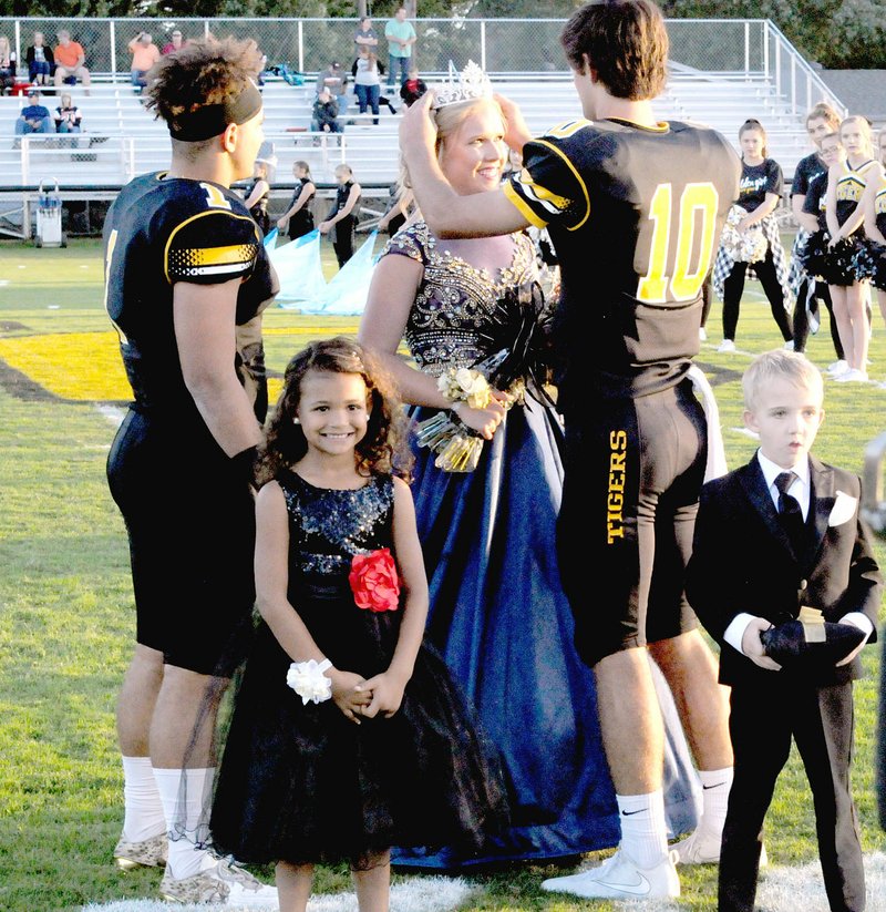 MARK HUMPHREY ENTERPRISE-LEADER Prairie Grove senior Emily Smith, daughter of Doug and Christina Smith, is crowned 2017 Homecoming queen by team captain John David Elder, while co-captain Anthony Johnson, looks on, and attendants Anniyah Hood, and Lucas Hood stand poised to do their part in the celebration.