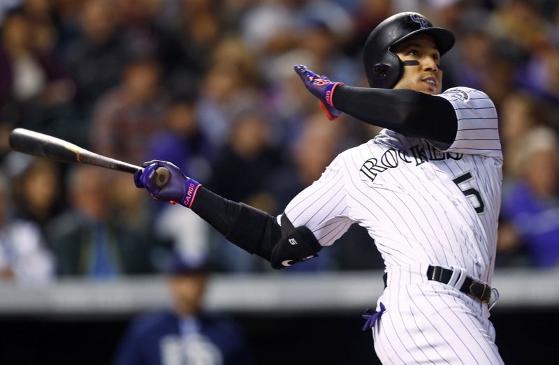 FILE - In this Sept. 16, 2017, file photo, Colorado Rockies' Carlos Gonzalez follows the flight of his two-run home run off San Diego Padres starting pitcher Jordan Lyles in the fifth inning of a baseball game in Denver.  (AP Photo/David Zalubowski, File)