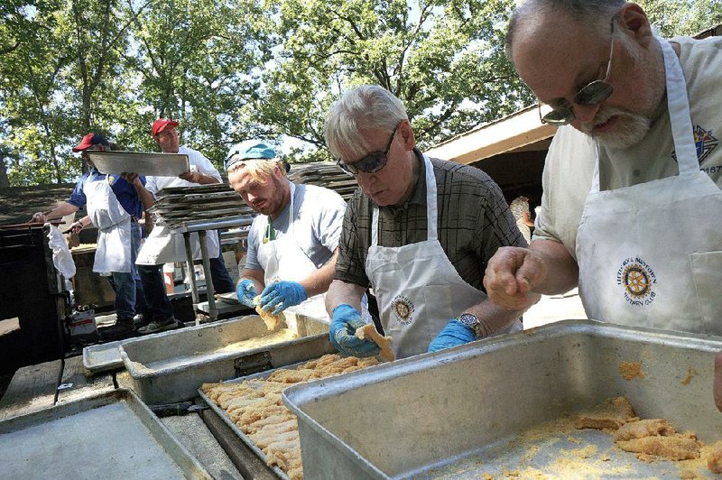 Volunteers from the Little Rock Midtown Rotary Club and the Knights of Columbus work on battering fish to feed the crowds at the Camp Aldersgate Fish Fry. 