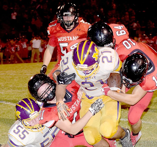 Photo by Rick Peck McDonald County&#8217;s David Roark (11), Caleb Curtis (10) and Trey Black (64) bring down Monett&#8217;s Patrick Valentine during the Mustangs 21-18 win on Sept. 29 at MCHS.