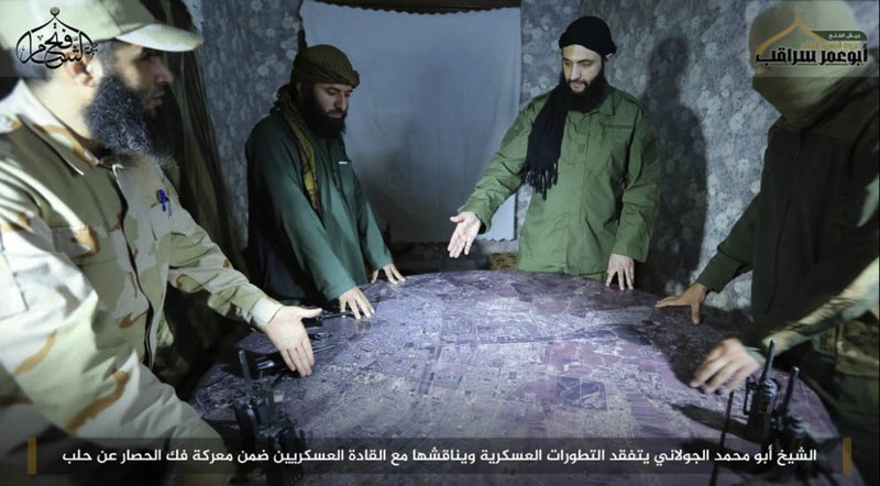 FILE -- This undated file photo, shows Abu Mohammed al-Golani, second right, then leader of Fatah al-Sham Front, in pictures posted by the group, discussing battlefield details with field commanders over a map, in Aleppo, Syria. Russia's military announced Wednesday, Oct. 4, 2017, that it carried out airstrikes in Syria this week that critically wounded al-Golani, the leader of the al-Qaida-linked Levant Liberation Committee and killed 12 other militant commanders.  (Militant UGC via AP, file)