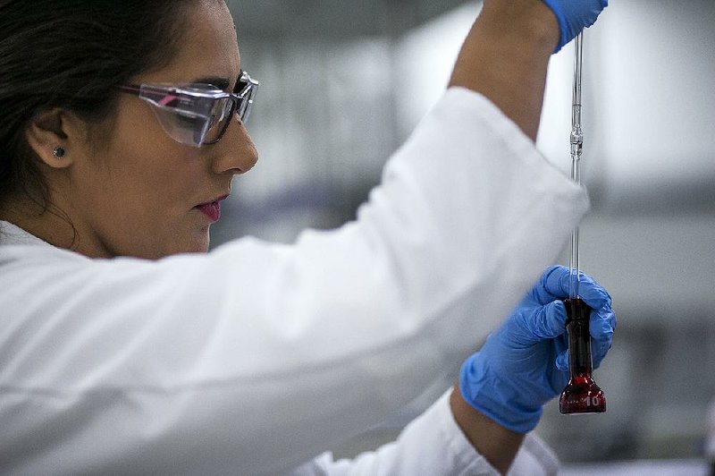 An analyst performs a test on a product inside the PuraCap Pharmaceutical LLC Caribe laboratory in Dorado, Puerto Rico, in August. The pharmaceutical industry accounts for almost 25 percent of the island’s gross domestic product.