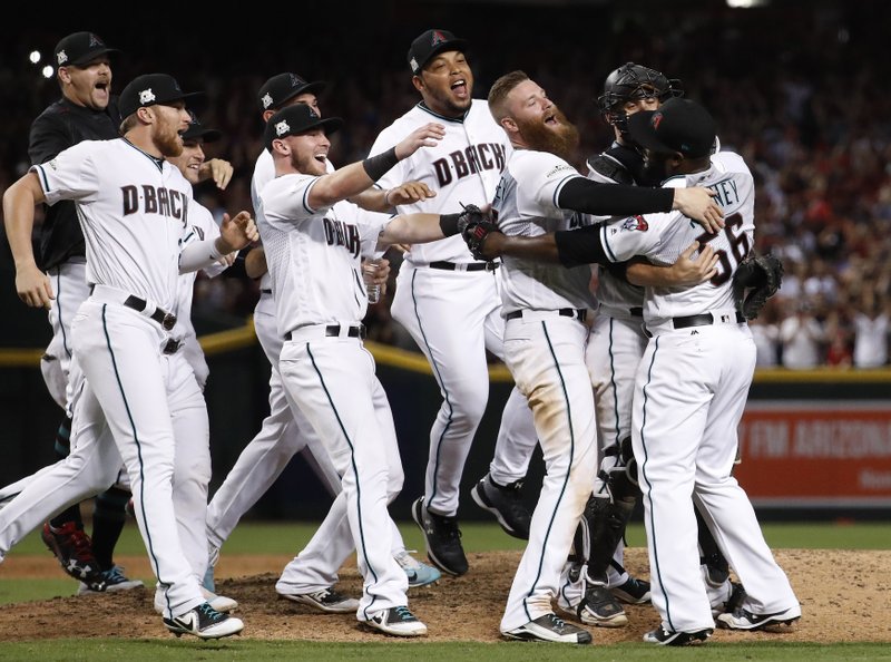 The Arizona Diamondbacks celebrate after the National League wild-card playoff baseball game against the Colorado Rockies, Wednesday, Oct. 4, 2017, in Phoenix. The Diamondbacks won 11-8 to advance to an NLDS against the Los Angeles Dodgers. 
