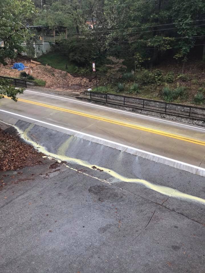 The Arkansas Transportation Department painted stripes on Arkansas 23 through Eureka Springs on Wednesday, but rain quickly washed the yellow paint off the road and into East Leatherwood Creek. (Photo by Damon Henke)
