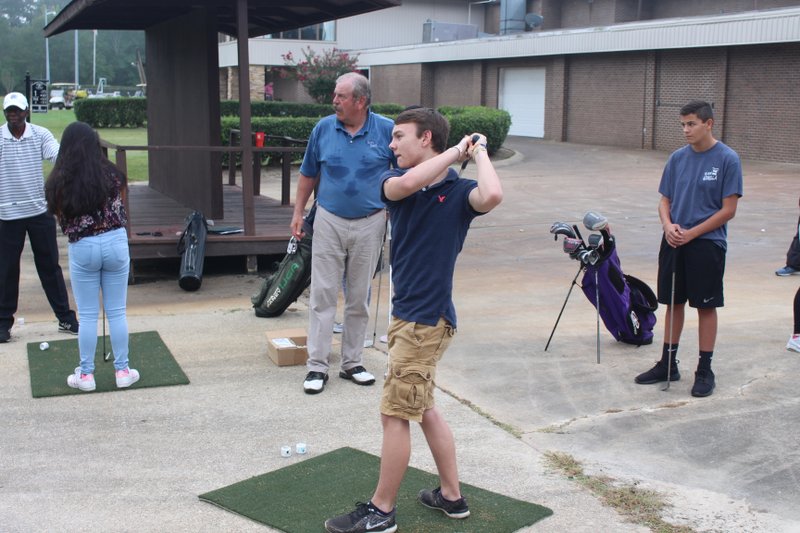 El Dorado High School student Landon Vinson looks out onto the green as he finishes a golf swing during class at the El Dorado Golf & Country Club. Brittany Williams/News-Times