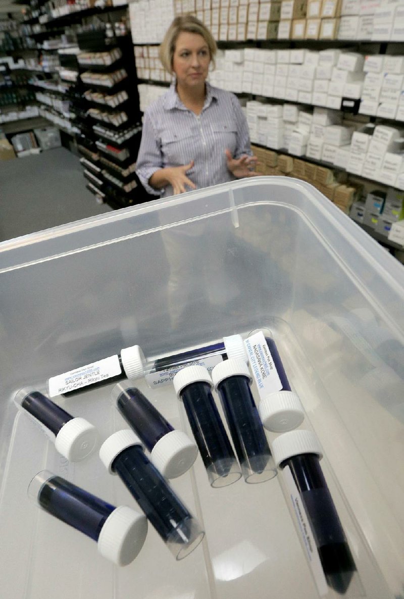 Lisa Vanness stands near a tub of ink samples at Vanness, a west Little Rock store that specializes in fountain pens.