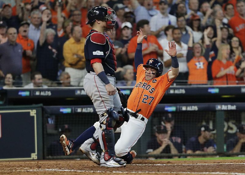 Houston Astros’ second baseman Jose Altuve (27) scores one of four sixth-inning runs to help lift them to an 8-2 victory over the Boston Red Sox in the American League division series. The Astros lead the series 2-0.  
