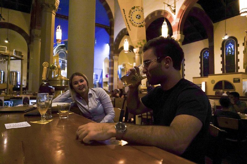 Jesse Hulien has a beer with Molly Hartman at the bar at Church Brew Works, a Pittsburgh sanctuary renovated into a brewery. 