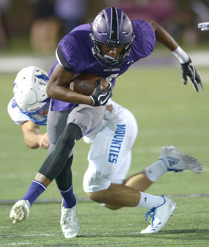 NWA Democrat-Gazette/ANDY SHUPE Fayetteville receiver Kris Mulinga (front) tries to break away from Rogers High linebacker Timothy Howard on Friday at Harmon Stadium in Fayetteville. Visit nwadg.com/photos for more photos from the evening's game.