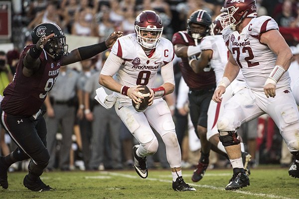 Arkansas quarterback Austin Allen (8) attempts to escape pressure from South Carolina defensive lineman Dante Sawyer, left, during the second half of an NCAA college football game Saturday, Oct. 7, 2017, in Columbia, S.C. (AP Photo/Sean Rayford)

