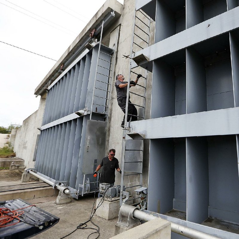 Workers shut the floodgate separating St. Bernard Parish from the East Bank of Plaquemines Parish on Saturday in Violet, La., as Hurricane Nate drew near. 