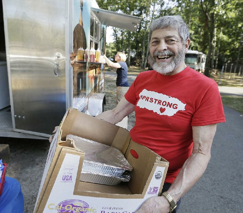 Joseph Badame helps out Sept. 29 at a food truck fundraiser for the people of Puerto Rico in Med-ford, N.J. Badame, who filled the basement of his now-foreclosed-on home with food and supplies, is passing his barrels of goods on to the people of the island.