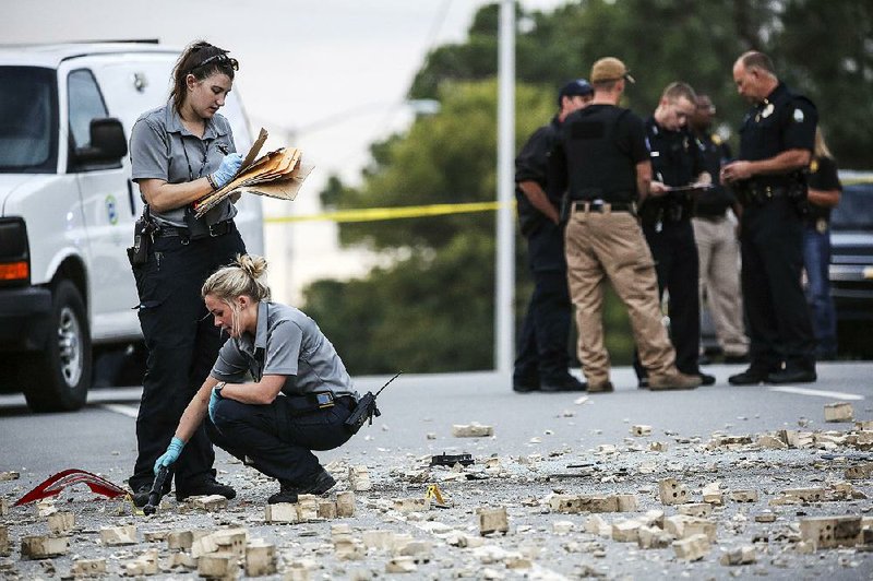 Investigators collect evidence at the scene of an officer-involved shooting on Oct. 7, 2017 outside the Prospect Building at 1501 N. University Ave. in Little Rock. 