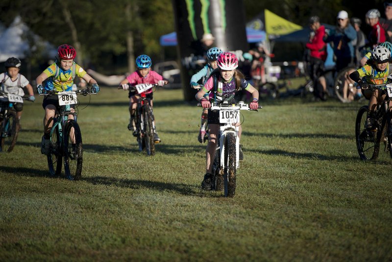 Young riders take off during a bike race on Sunday at Slaughter Pen Mountain Bike Park in Bentonville. There are several mountain biking events that are scheduled to come to Bentonville next year after organizers attended the IMBA World Summit last year.