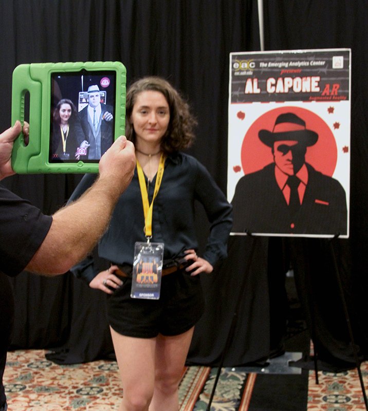 The Sentinel-Record/Grace Brown Loki Rasmussen helps demonstrate the Al Capone Virtual Selfie application brought to the Hot Springs Documentary Film Festival by the Emerging Analytics Center at the University of Arkansas at Little Rock. The application, that was featured the first weekend of the festival, allowed guests to take a virtual selfie with the mobster using augmented reality.