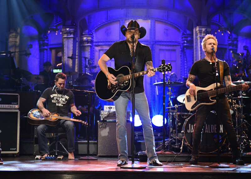 In this photo provided by NBC, Jason Aldean performs "I Won't Back Down" on "Saturday Night Live," Saturday, Oct. 7, 2017, in New York. “Saturday Night Live” has paid tribute to the victims of the Las Vegas mass shooting and the late rock superstar Tom Petty by opening its show with country star Aldean singing one of Petty’s songs.