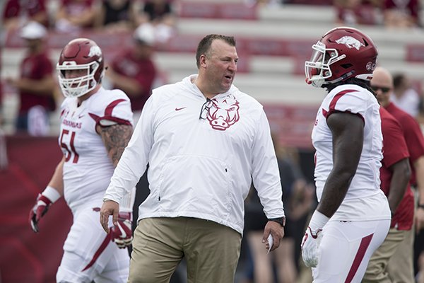 Arkansas coach Bret Bielema talks with defensive lineman McTelvin Agim prior to a game against South Carolina on Saturday, Oct. 7, 2017, in Columbia, S.C.