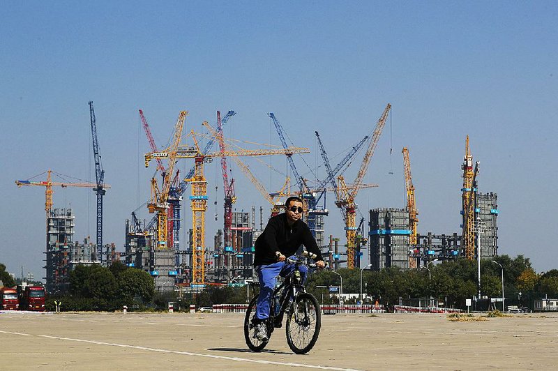 A man passes a construction site near Olympic Park in Beijing last week. The International Monetary Fund expects China, the secondbiggest economy, to post faster growth this year for the first time since 2010. 