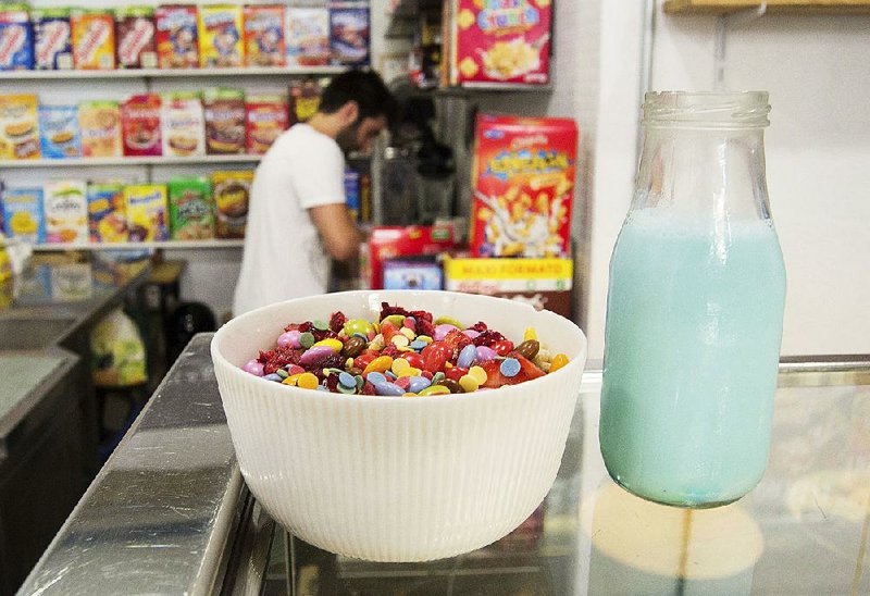 A bowl of sugary cereals, topped with candy, is displayed at El Flako in Barcelona, Spain, as one of the cafe owners, Nicolas Castan, prepares a more healthful combination.