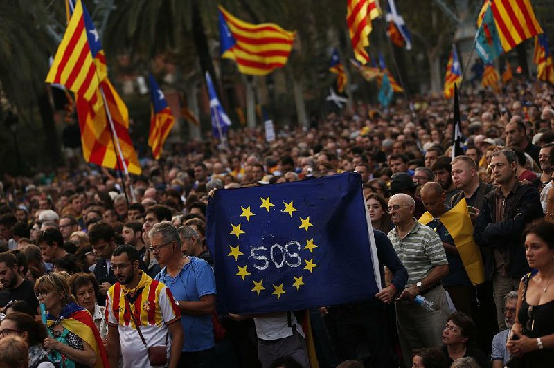 Supporters of independence for the Catalonia region hold up a message on a European Union flag Tuesday during a rally in Barcelona, Spain. 