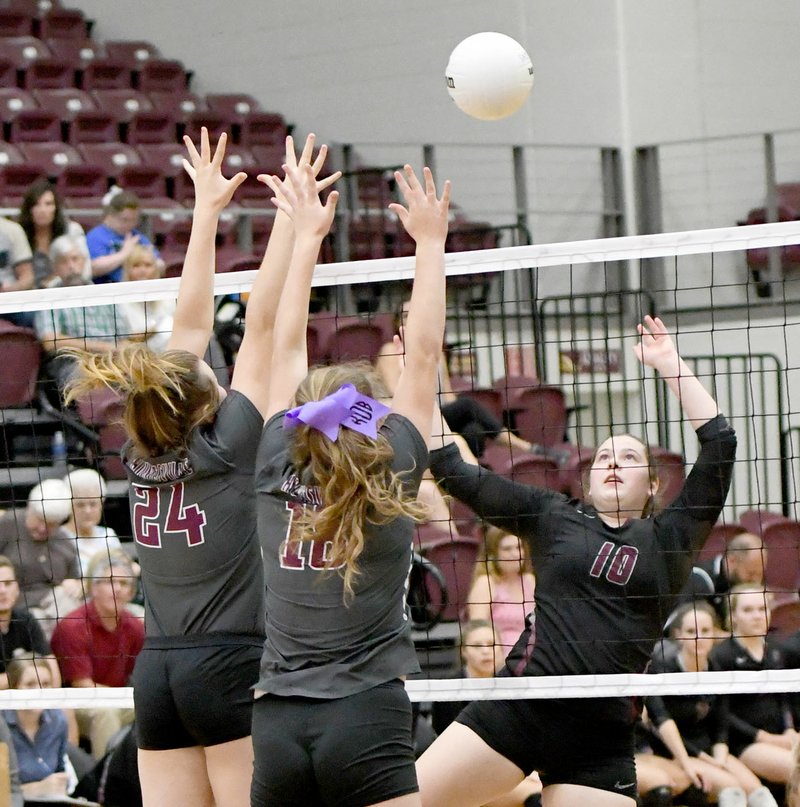 Bud Sullins/Special to the Herald-Leader Siloam Springs senior Allie Bowman, right, goes up for a hit against Huntsville's block of Destinee Harmon, No. 24, and Cori Wylie during a match on Sept. 19 at Panther Activity Center.
