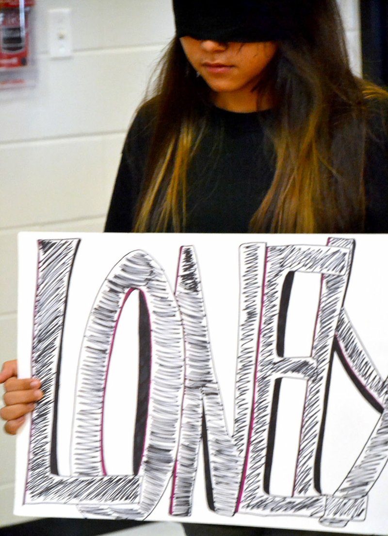 Carrying signs labeling the various negative emotions a victim of bullying may feel, Pea Ridge Middle School student peer mediators began an anti-bullying program Friday afternoon.